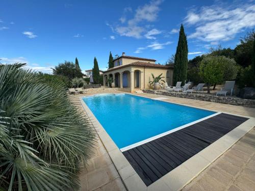 une piscine devant une maison dans l'établissement Villa Les amandiers avec piscine, à Saint-Laurent-de-la-Cabrerisse