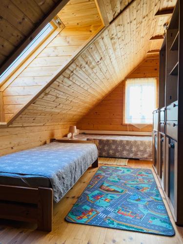 a attic bedroom with a bed and a rug at Holidayhome Juksty in Mrągowo