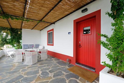 a red door on the side of a building with chairs at Casas de Juromenha in Juromenha