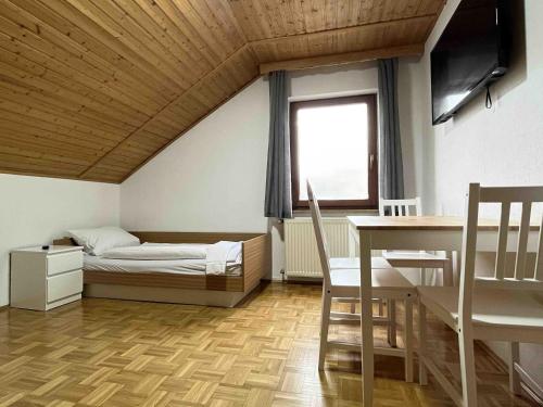 a bedroom with a bed and a table and a window at SAD503 - Praktische Monteurwohnung in Schwandorf in Bayern