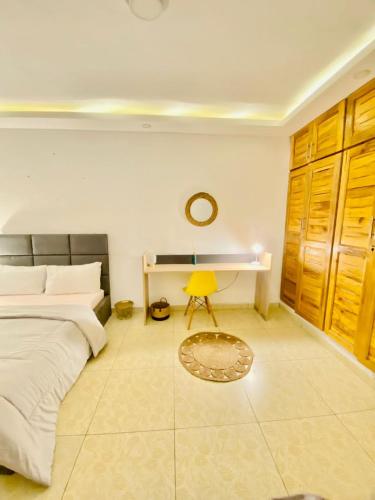 a bedroom with a bed and a desk and a yellow chair at Résidence cosy or in Douala