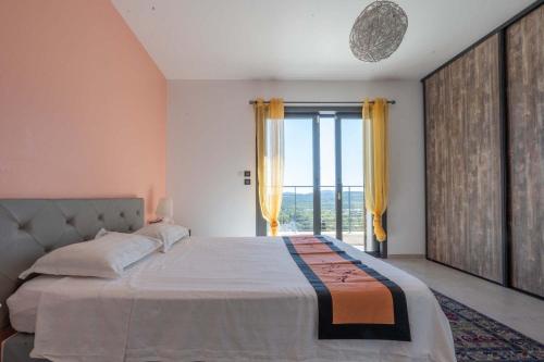 une chambre avec un grand lit et une grande fenêtre dans l'établissement 83bouis, à Montauroux