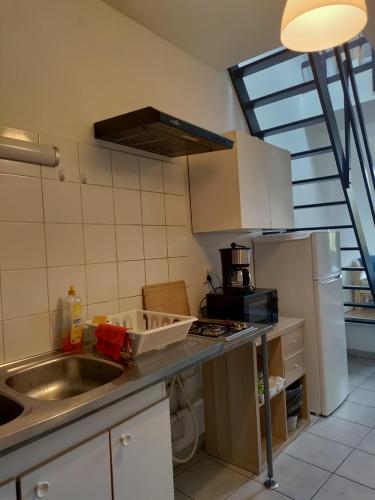 une petite cuisine avec un évier et un réfrigérateur dans l'établissement Duplex Metz 4 couchages, à Metz