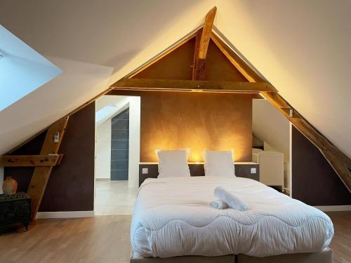 une chambre avec un grand lit dans un grenier dans l'établissement La Molinière, belle demeure avec séjour cathédrale - La Molinière, beautiful residence with cathedral living room, à Les Montils