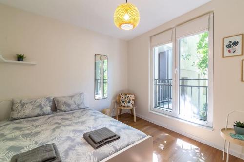 a bedroom with a bed and a large window at Peaceful retreat - free parking in Plovdiv