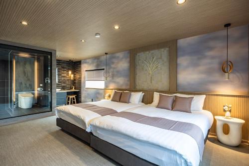 a bedroom with a large bed and a bathroom at JAPAVISTA Yamato in Osaka