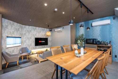 a dining room and living room with a wooden table at JAPAVISTA Yamato in Osaka