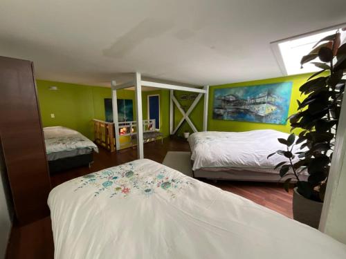 a bedroom with two beds and a large window at Apart Hotel Jagui Haus Departamentos tipo Loft y Hermosa Terraza con vista al Mar in Valparaíso