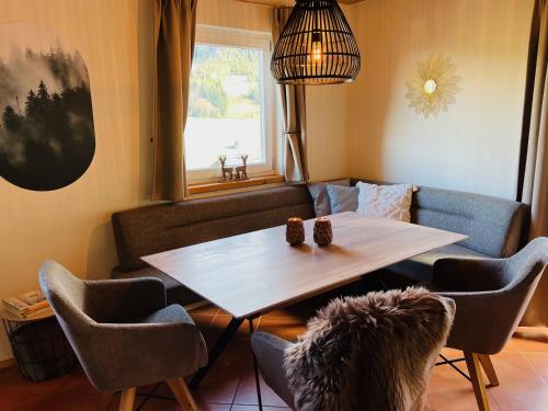 salon ze stołem, krzesłami i kanapą w obiekcie Alpendorf Dachstein West by ALPS RESORTS w mieście Annaberg im Lammertal