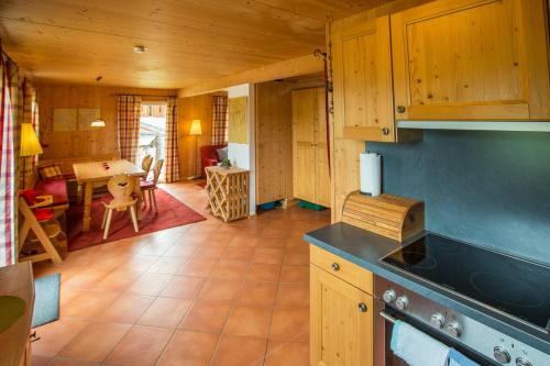 a kitchen with wooden cabinets and a dining room at Alpendorf Dachstein West by ALPS RESORTS in Annaberg im Lammertal
