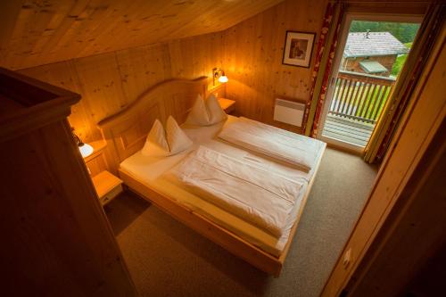 a bedroom with a bed in a room with a window at Alpendorf Dachstein West by ALPS RESORTS in Annaberg im Lammertal