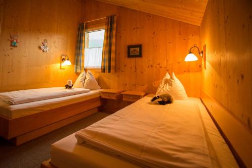 two beds in a room with two cats sleeping on them at Alpendorf Dachstein West by ALPS RESORTS in Annaberg im Lammertal