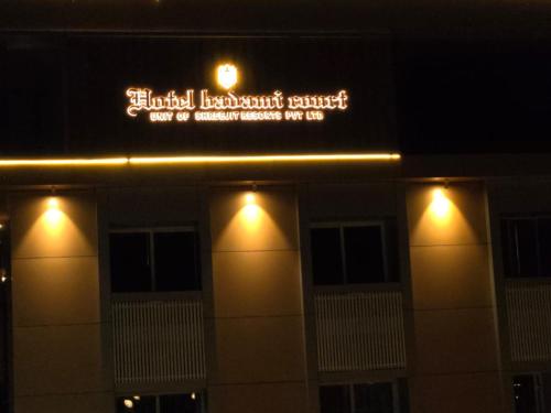 a sign on the side of a building with lights at Hotel Badami Court in Badami