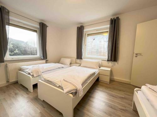 una camera bianca con due letti e due finestre di SAD801 - Geräumige Monteurwohnung a Schwandorf