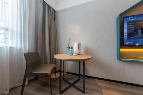 a small table with a chair and a tv on a wall at Echarm Hotel Potala Palace Da Zhao Temple Branch in Lhasa