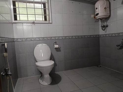bagno con servizi igienici bianchi e finestra di Trilan Cottages - Donnington Road a Kotagiri