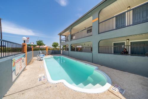 a swimming pool in front of a building at Super 8 by Wyndham San Antonio/Riverwalk Area in San Antonio