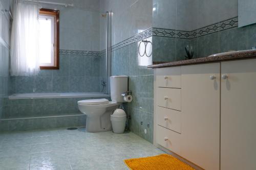a bathroom with a toilet and a tub and a sink at sand and sea in Póvoa de Varzim