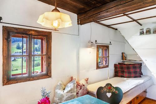 a small room with a bed and a window at Kastnhäusl Wildschönau Urige Hütte in Oberau