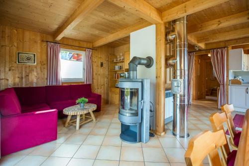 a living room with a red couch and a fireplace at Alpendorf Dachstein West by ALPS RESORTS in Annaberg im Lammertal