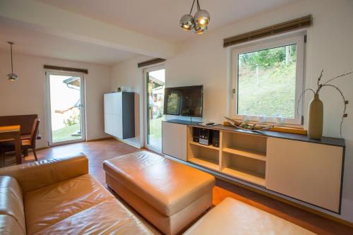 a living room with a couch and a tv at Alpendorf Dachstein West by ALPS RESORTS in Annaberg im Lammertal