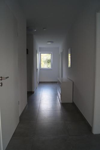 an empty room with a hallway with a window at Freundliche Ferienwohnung in Bielefeld Senne in Bielefeld