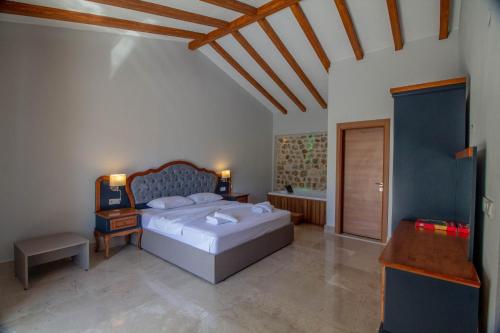 a bedroom with a bed and a desk and a bed sidx sidx sidx at Tlos Deluxe 3+1 Villa ,Özel Havuzlu, Fethiye in Fethiye