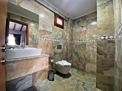 a bathroom with a sink and a toilet at Tlos Deluxe 3+1 Villa ,Özel Havuzlu, Fethiye in Fethiye