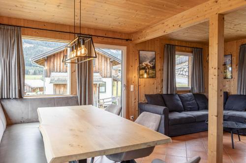 a living room with a table and a couch at Alpendorf Dachstein West by ALPS RESORTS in Annaberg im Lammertal