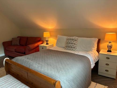 a bedroom with a bed and a couch at Church View, Poltimore Village - near Exeter in Exeter