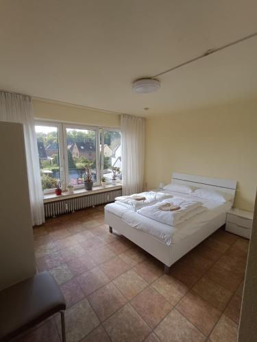 a bedroom with a large white bed and windows at Horrem City Apartments in Horrem