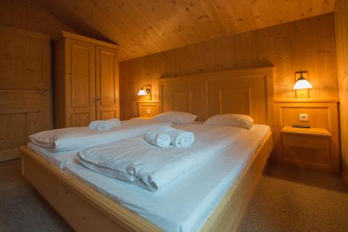 a bedroom with two beds with towels on them at Alpendorf Dachstein West by ALPS RESORTS in Annaberg im Lammertal