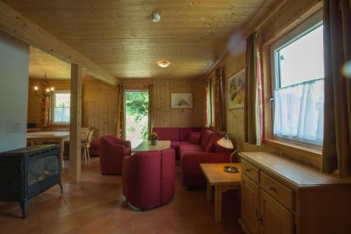 a living room with a red couch and a stove at Alpendorf Dachstein West by ALPS RESORTS in Annaberg im Lammertal
