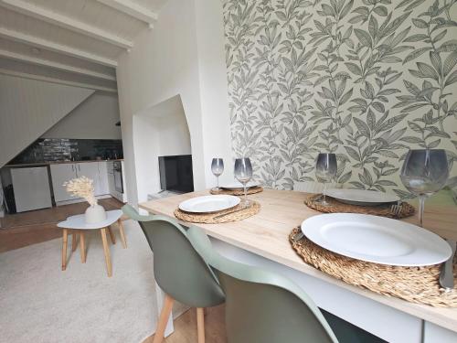 une salle à manger avec une table, des verres et des chaises dans l'établissement Le Stadium, coconning et design, à Brive-la-Gaillarde