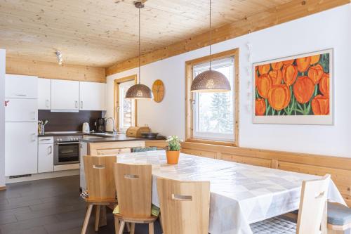 a kitchen with a table and chairs in a kitchen at Alpendorf Dachstein West by ALPS RESORTS in Annaberg im Lammertal