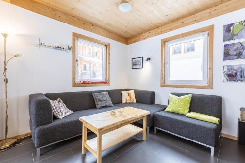 a living room with a couch and a table at Alpendorf Dachstein West by ALPS RESORTS in Annaberg im Lammertal