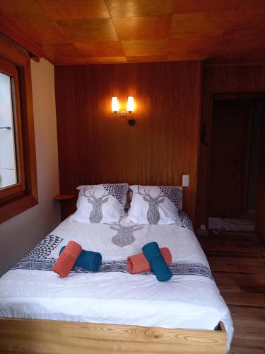 a bed with three pillows on it in a room at Appartement avec Terrasse in Chamonix-Mont-Blanc