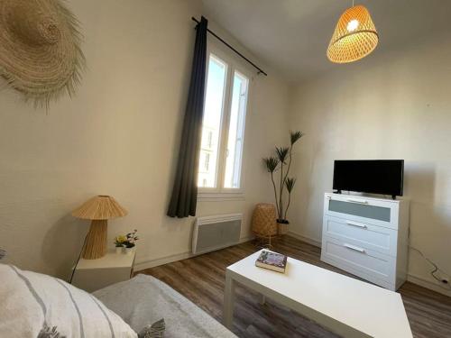 un salon avec un lit et une télévision dans l'établissement Joli Studio à 100m des plages, à Toulon