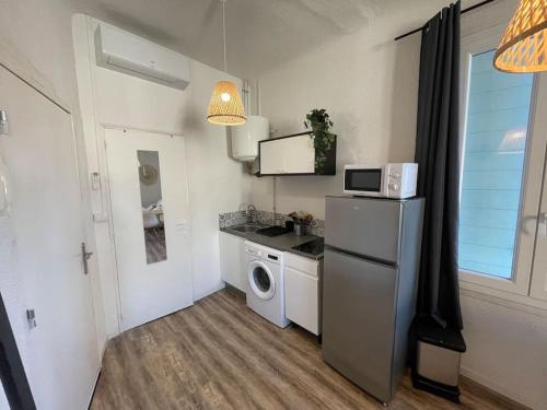 une cuisine avec un réfrigérateur et une machine à laver dans l'établissement Joli Studio à 100m des plages, à Toulon