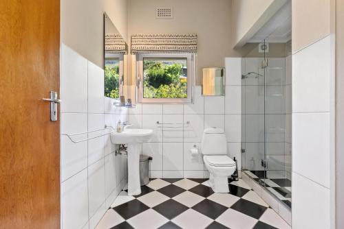 a bathroom with a sink toilet and a window at Villa Blue Sky Cape Town in Cape Town
