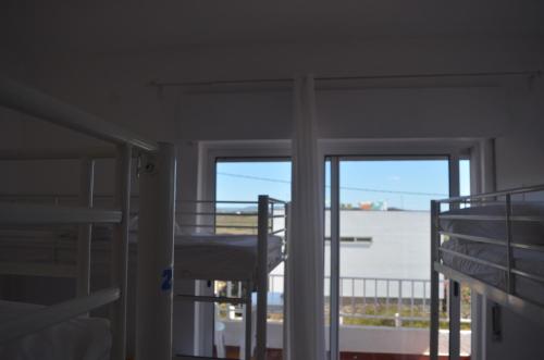 a room with two bunk beds and a balcony at Blife Faro Beach Hostel & Rooms in Faro