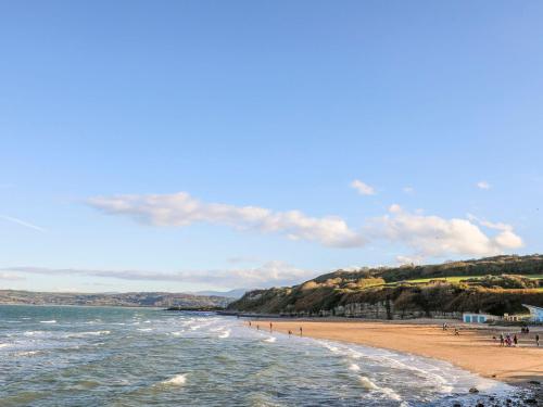 a beach with a group of people standing on the sand at Hedd in Amlwch