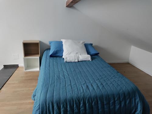- une chambre avec un lit doté de draps bleus et d'oreillers bleus dans l'établissement Duplex Metz 4 couchages, à Metz