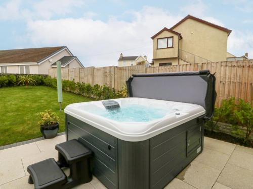 a hot tub in the backyard of a house at Hedd in Amlwch