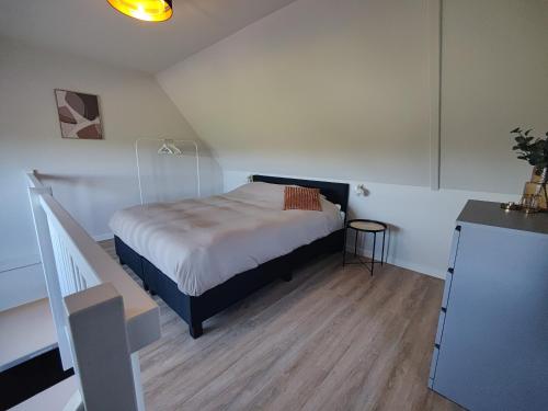 a small bedroom with a bed and a staircase at B&B de Gouden Ploeg met Jacuzzi in Bergentheim