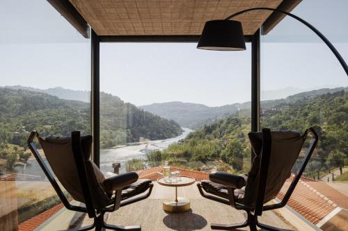 two chairs and a table on a balcony with a view at Dajas Douro Valley - Exclusive Villas in Sande