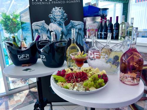 a table with a plate of food and bottles of wine at Riviera 990 - Resort & Restaurant in Eşelniţa