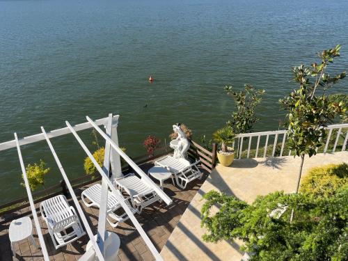 a group of chairs sitting on a deck next to the water at Riviera 990 - Resort & Restaurant in Eşelniţa
