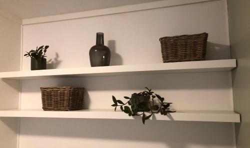 a white shelf with a bottle and a plant at Het Natuurhuisje op de Veluwe in Nunspeet