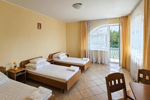 a hotel room with two beds and a window at Dom Pielgrzyma ARKA in Licheń Stary